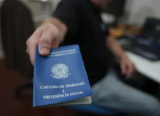 Homem segurando carteira de trabalho